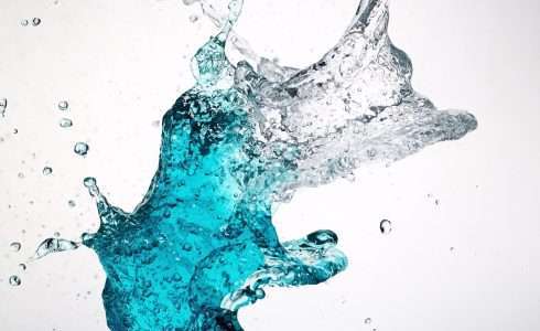 Liquid splash with blue tint against a white background, reminiscent of the pristine waters found in Idaho.