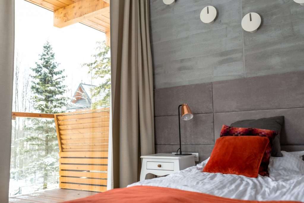 A cozy bedroom in Idaho with a view of snow-covered trees from the adjacent balcony.