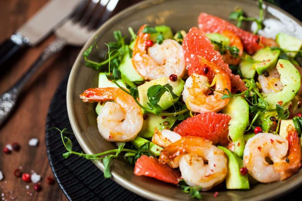 Grilled shrimp and avocado salad with grapefruit slices and a sprinkle of pomegranate seeds, enjoyed in Meridian.