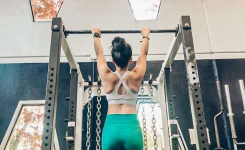 Woman performing pull-ups at a gym in Meridian, Idaho.