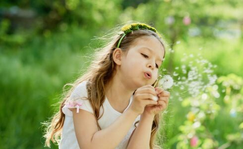 girl blowing dandelions in Meridian Boise, ID during allergy season