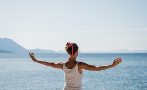 Young woman morning meditation by the sea
